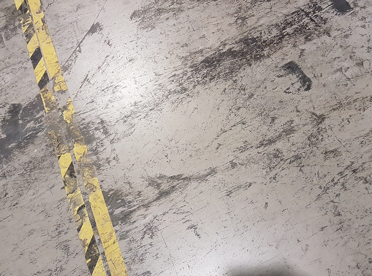 Concrete floor with a yellow and black striped line running across it