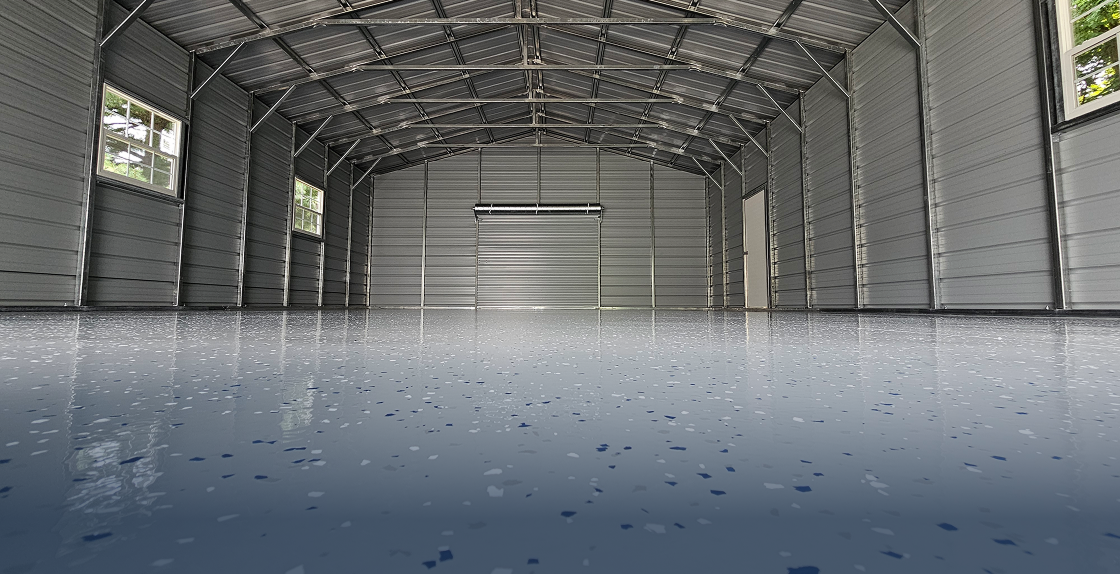Empty garage with a metal roof and windows, and a garage floor with a garage door in the background