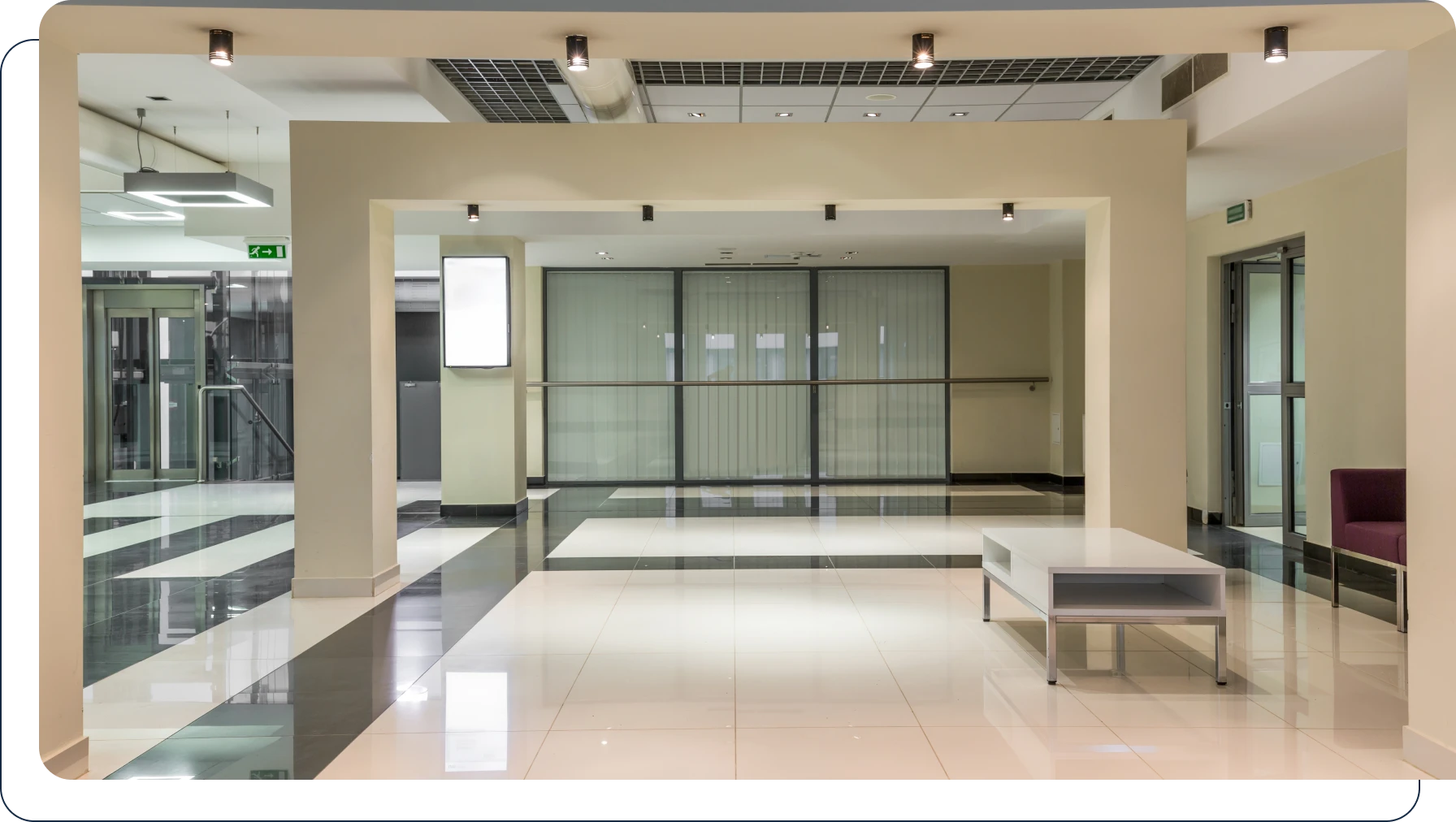 Large lobby with a white table and chairs, a sofa, a pillar, a railing, glass doors, a signboard, a roof